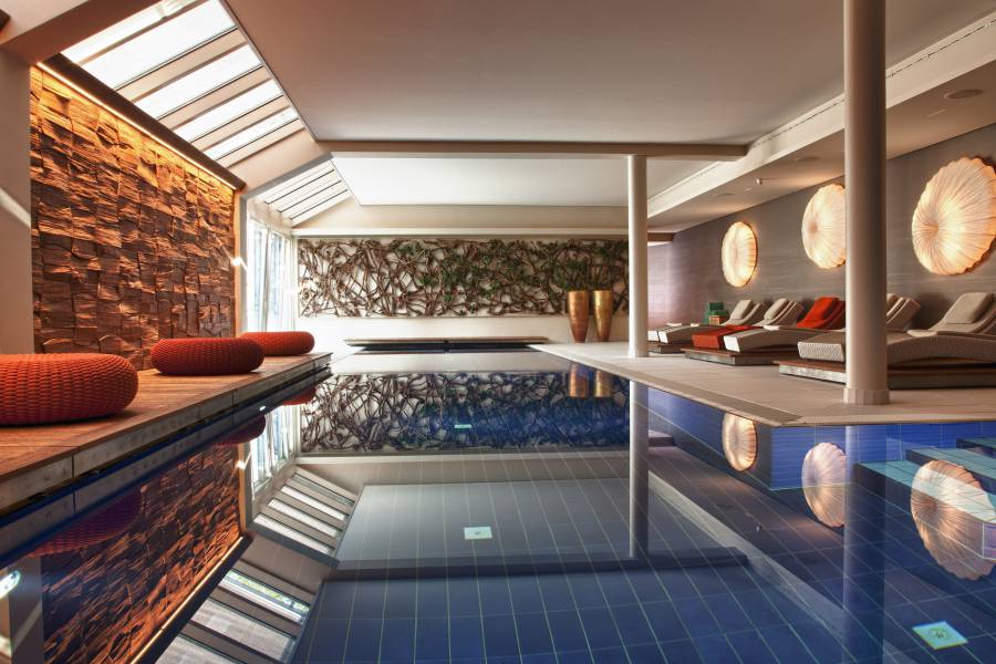 Indoor-Pool with sunbeads and poufs Strandhotel am Weissensee